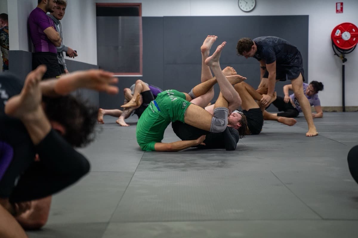 Two athletes rolling on the mat during a no-gi training session